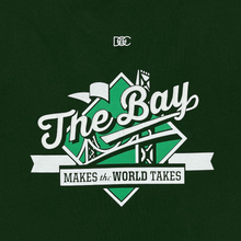 Load image into Gallery viewer, Detailed close-up of The Bay Makes The World Takes green and white logo graphic on a forest green t-shirt.