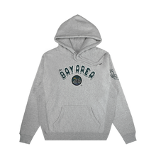 Load image into Gallery viewer, The Bay Area CC Hoodie By DOC from Oaklandish is a light gray heavyweight fleece men’s pullover with “BAY AREA” in varsity dark green on the chest, a landscape patch beneath, front pocket, and building sketch on the left sleeve.